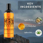 Business As Usual Shampoo in a black bottle with a bright orange label, featuring The Man Brand lettering and ingredient graphics.
