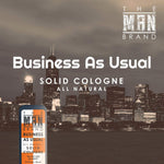 Business As Usual Solid Cologne in a blue and orange vintage slide tin, featuring bold black and white lettering.