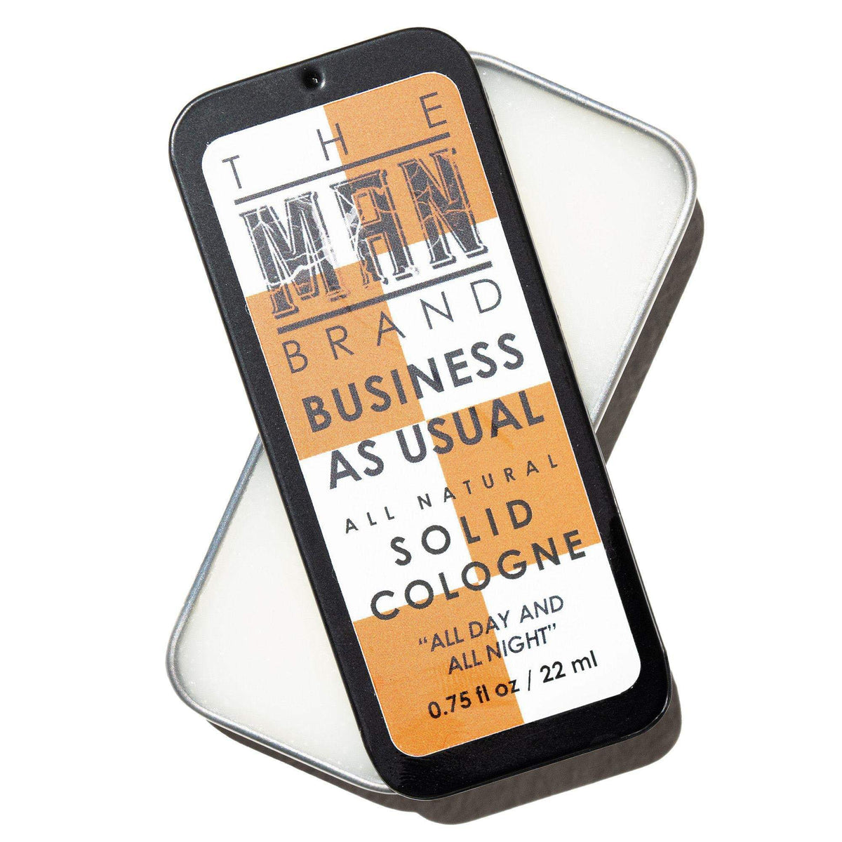 Business As Usual Solid Cologne in a black metal slide tin with an orange and cream label and bold lettering.