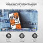 Business As Usual Solid Cologne in a dark gray slide tin with an orange, white and black label, featuring bold branding.