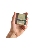 Solid cologne in a compact olive-green and brown tin, with a Cedarwood Blend label and white lettering.