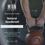 Natural deodorant in charcoal packaging with white typography, featuring Gentlemen's Bourbon Natural branding and a 32 kg kettlebell graphic.