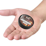Solid cologne in a black round tin, featuring a brown woodgrain-patterned label marked Gentlemen's Bourbon.