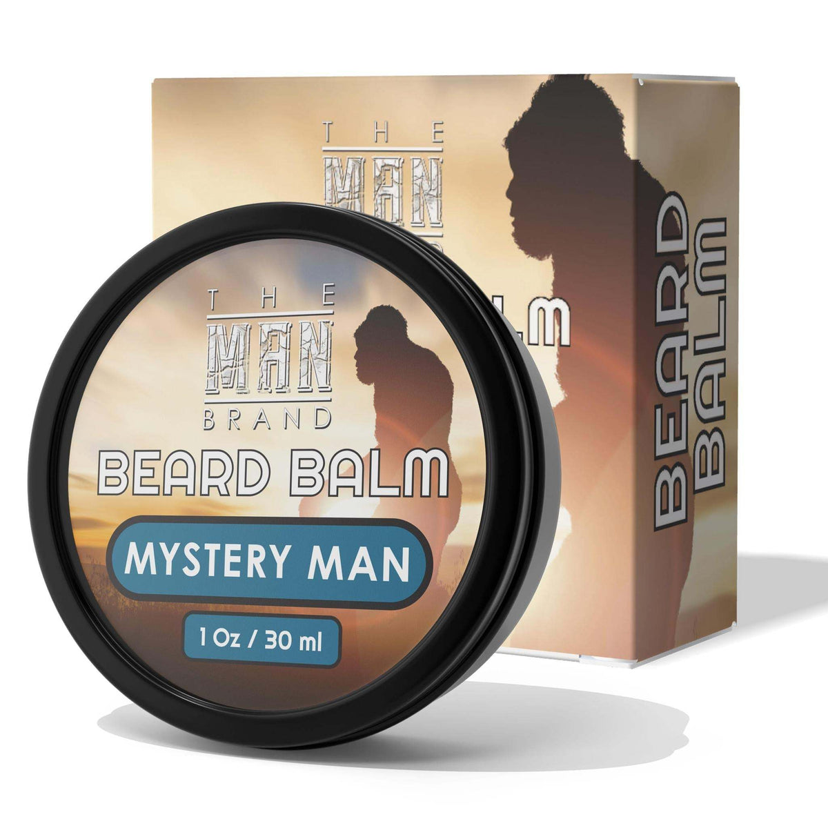 Mystery Man Beard Balm in a black round tin with a tan-and-brown label, blue accents, and matching carton packaging.