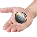 Mystery Man Beard Balm in a small black round tin with a gold-and-blue label and cedarwood blend branding
