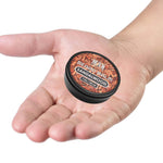 Sandalwood Beard Balm in a small black round tin, with an orange wood-grain label and white lettering.