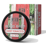 Sweet Tobacco Beard Balm in a black round tin, with a red, green and white rustic woodgrain label and matching box.