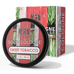 Sweet Tobacco Solid Cologne in a black round tin, with red, green and woodgrain packaging labeled Sweet Tobacco.
